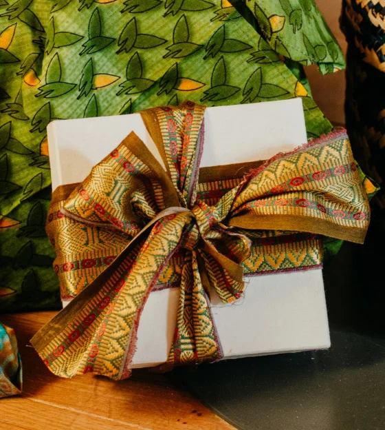 Symbolbild: Geschenkschachtel mit aufwändiger goldfarbener Schleife