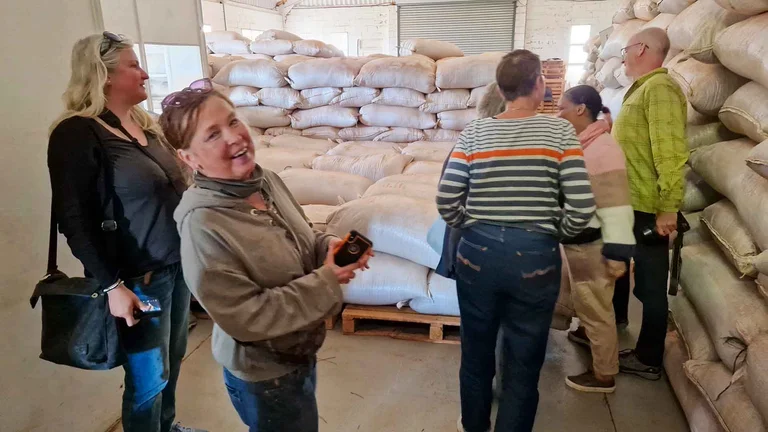 Fünf Personen in einem Lagerraum voller weißer Säcke