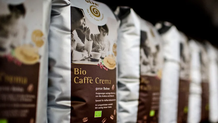 Eine Reihe GEPA Caff&egrave; Crema Packungen steht im Regal.