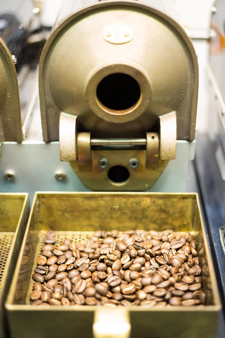 Frontaler Blick auf eine kleine, messingfarbene Kaffeer&ouml;stmaschine.