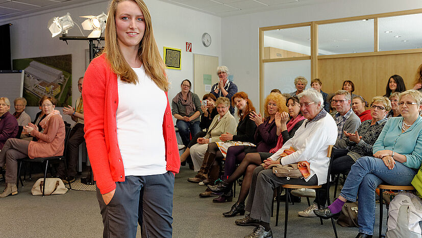 Prima Kombipartner: Das weiße Basic-Shirt der GEPA mit der anukoo-Hemdbluse in Koralle und der nachtblauen Damenhose, ebenfalls von anukoo.