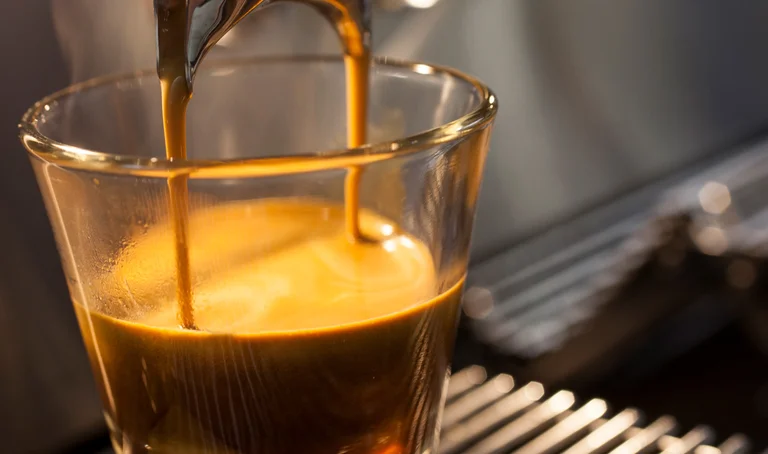 Espresso läuft aus einer Siebträgermaschine ins Glas.