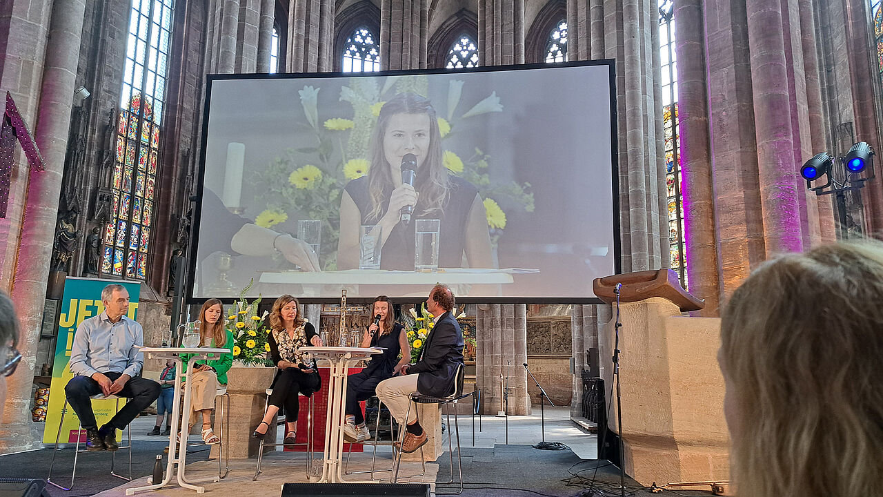 Auf dem Podium in der Sebalduskirche: Dr. Martin Herrmann (Deutsche Allianz Klimawandel und Gesundheit), Klimapsychologin Janna Hoppmann, Klimaaktivistin Luisa Neubauer und Prof. Dr. Harald Kunstmann, Direktor Zentrum für Klimaresilienz, Uni Augsburg.