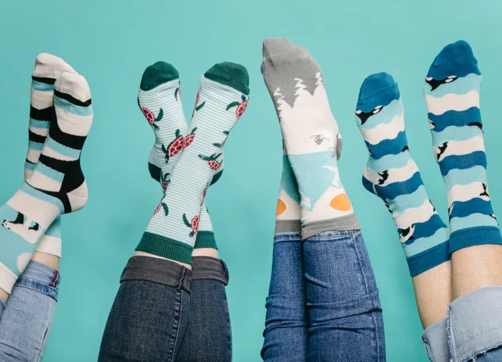 Sechs in die Luft gestreckte Beinpaare mit verschiedenen Socken