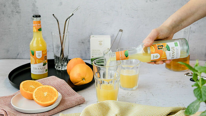 Step 3: Eine Flasche GEPA Bio Limo Orange gleichmäßig auf zwei Gläser verteilen. Wichtig ist, dass die Limo gut gekühlt ist!