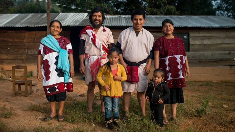 Mexikanische Familie in 3 Generationen posiert vor einer Hütte