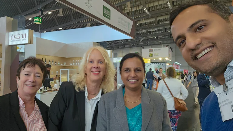 Ein Mann macht ein Selfie von sich und drei Frauen auf einem Messegel&auml;nde. Auf seinem Namensschild steht "Gautam Mohan, Tea Promoters India".