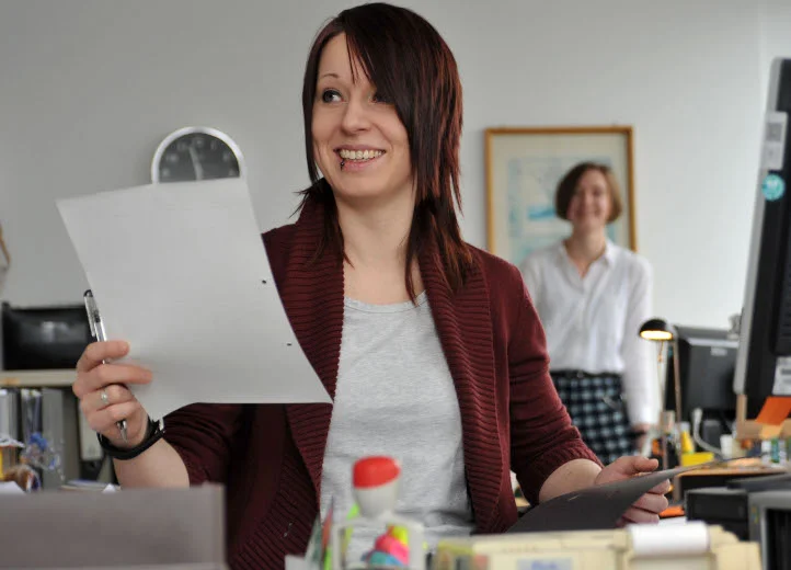 Junge Frau mit einem Blatt Papier in einem Büro