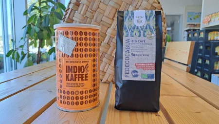 Eine Kaffeedose "Indio Kaffee" neben einer Packung GEPA-Kaffee (Fedecocagua) auf einem Holztisch