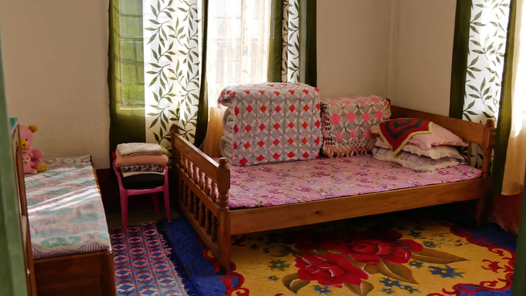 Blick ins Wohnzimmer. Bunte, gemusterte Stoffe pr&auml;gen das Bild.