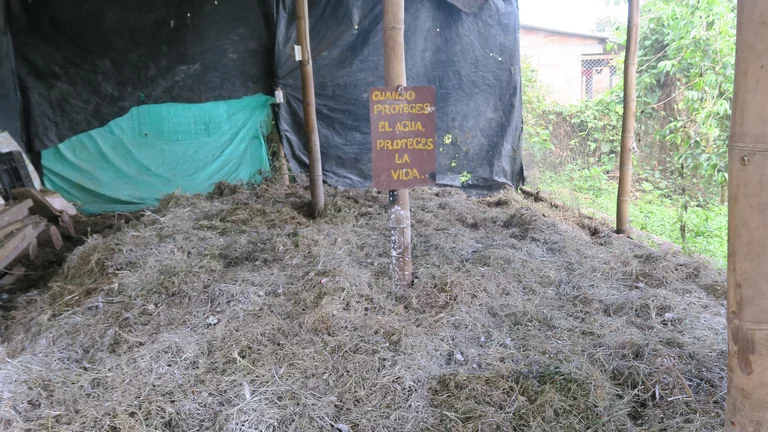 Komposthaufen, darin steckt ein Schild.