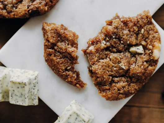 Ein angebrochener Keks von oben, daneben St&uuml;cke eines Schokoriegels