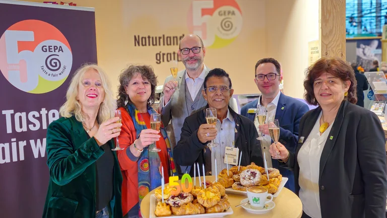 Barbara Schimmelpfennig (GEPA-Pressesprecherin), Andrea Fütterer (GEPA-Leiterin Abteilung Grundsatz und Politik), Peter Schaumberger (GEPA-Geschäftsführer), Bernard Ranaweera (Präsident von GEPA-Handelspartner SOFA, Sri Lanka), Wilhelm Heilmann, Geschäftsführer Naturland Zeichen GmbH und Karin Romeder (Mitglied der Geschäftsleitung bei Naturland Zeichen GmbH) mit Sekt auf der BIOFACH 2025