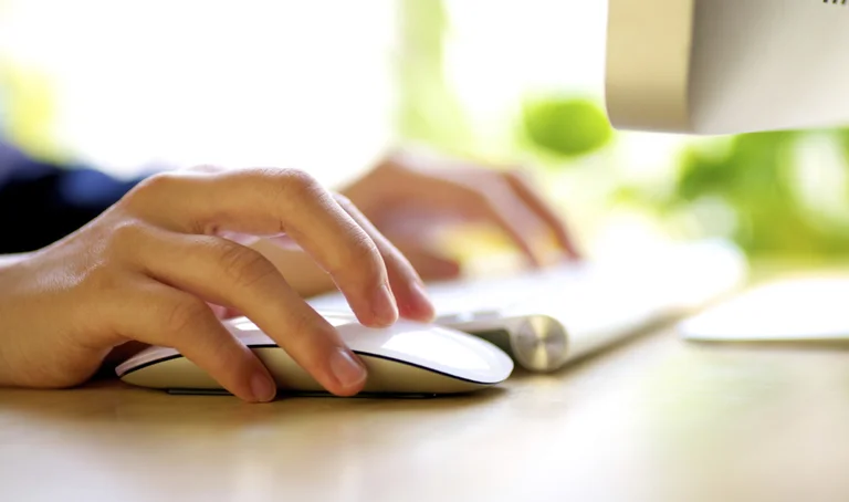 Nahaufnahme einer Hand, die auf einer Computermaus aufliegt