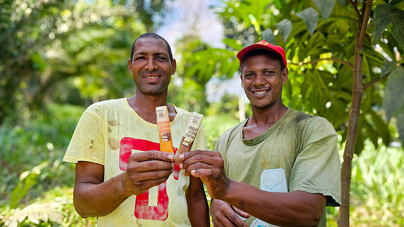 CECAQ-11 betreibt ein eigenes Aufforstungsprojekt – mitfinanziert durch die GEPA. Hier zeigen die beiden Arbeiter und Kakaobauern Yozalde Lopez Duarte (links) und Edney Lopez Duarte zwei GEPA-Riegel.