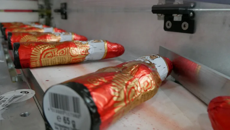 Rot verpackte Schoko-Nikoläuse auf einem Förderband