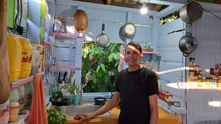 Junger Mann in einer Kochhütte in der Karibik