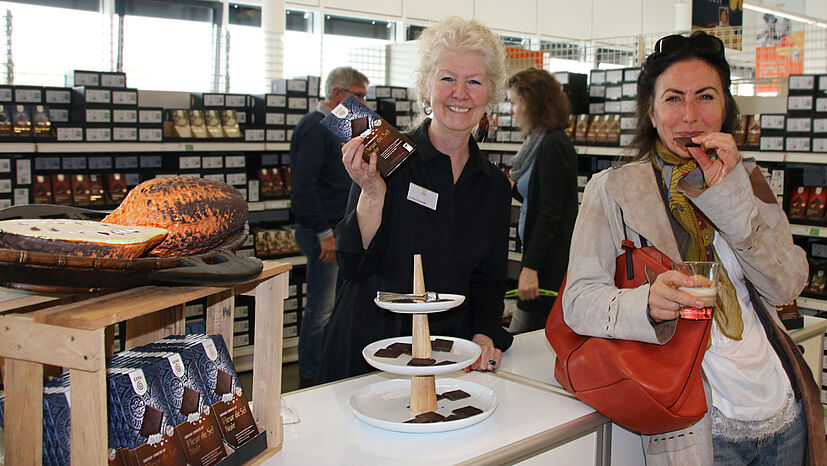 Lecker wurde es auch bei der Schokoladenverkostung: Hier konnten die Gäste die neue vegane Sorte „Fleur de Sel Noir“ mit hangedeschöpftem Pyramidensalz und 70 Prozent Kakaoanteil probieren. Evelin Frowein (links), GEPA Vertriebsassistentin Food Weltläden & Gruppen, beantwortete gern alle Fragen rund um faire GEPA-Schokoladen.