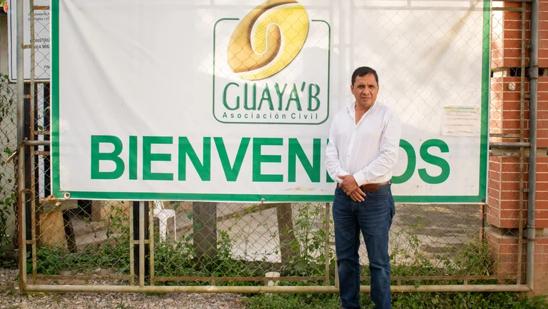 Mann vor einem großen Schild mit der Aufschrift "Bienvenidos"