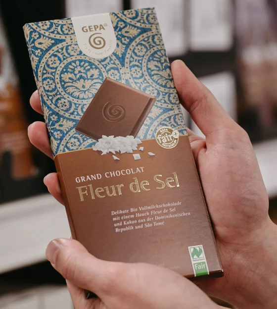 GEPA-Schokolade "Fleur de Sel", die in der Hand gehalten wird.