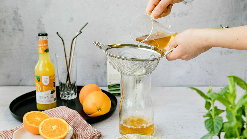 Step 2: Den Tee nach Ablauf der Ziehzeit durch ein Sieb mit Eiswürfeln (ca. 4 Stück) gießen, damit der Tee etwas abkühlt.