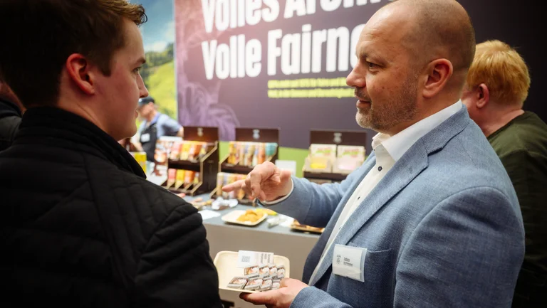 Zwei M&auml;nner im Gespr&auml;ch an einem Messestand der GEPA