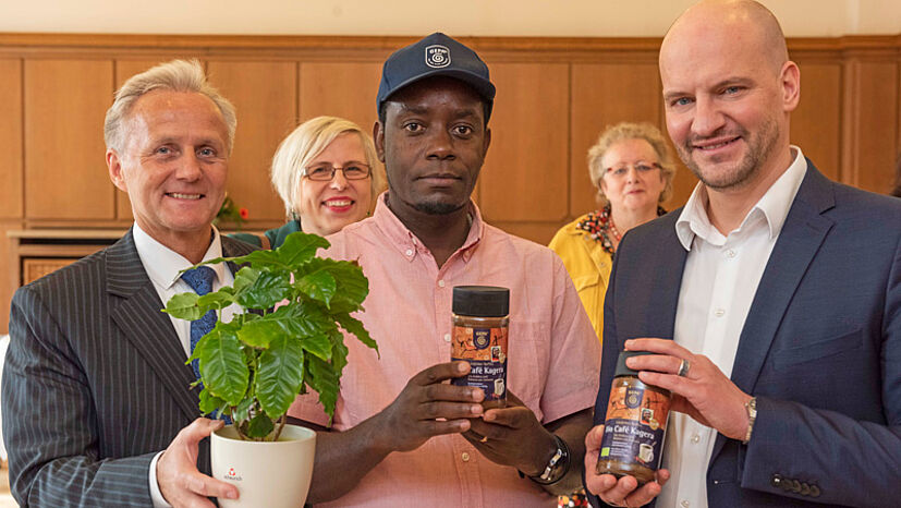 GEPA-Geschäftsführer Matthias Kroth und Josephat Sylvand, Exportmanager und Qualitätssicherung bei KCU überreichten Bürgermeister Marc Schulz zum Abschluss eine Kaffeepflanze sowie Bio Café Kagera, den die GEPA von KCU bezieht.