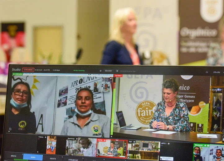Im Vordergrund Bildschirm mit verschiedenen Kameraeinstellungen des Livestreams.
