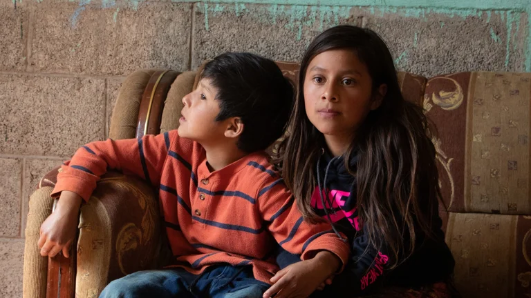 Zwei Kinder (Junge und M&auml;dchen) auf einem Sofa