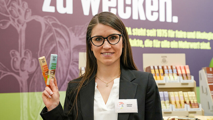 Anastasia Lisitcyna, GEPA Account-Managerin AHS, zeigt unser fair gehandeltes Riegel-Sortiment.