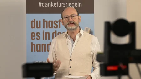 GEPA-Geschäftsführer Peter Schaumberger spricht mit Ansteckmikrofon vor GEPA-Bannern in eine vor ihn aufgestellte Kamera.