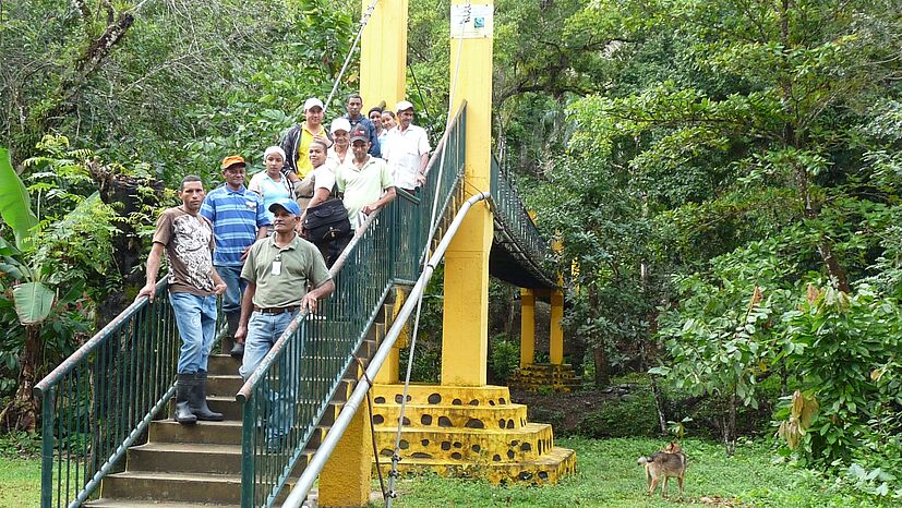 Bei der Genossenschaft COOPROAGRO in der Dominikanischen Republik konnte über den Fairen Handel diese Brücke gebaut werden. Sie verbindet nun bei jedem Wetter die 600 Familien der Gemeinde Chinguelo mit der Außenwelt. In der Regenzeit war der Fluss Nag