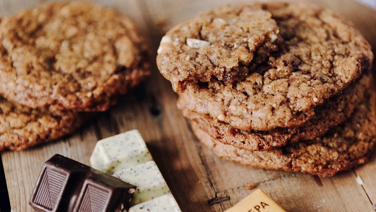 Ein Stapel Cookies und Schokoriegel auf einer Holzplatte