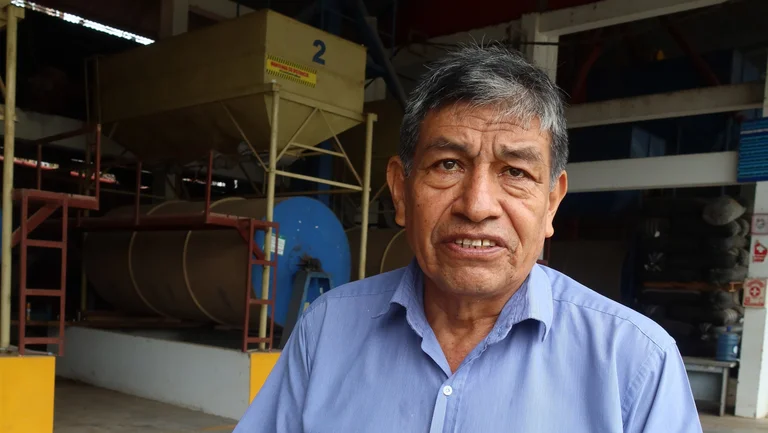 Portrait: ein Lateinamerikaner steht vor einer großen Kaffeeanlage