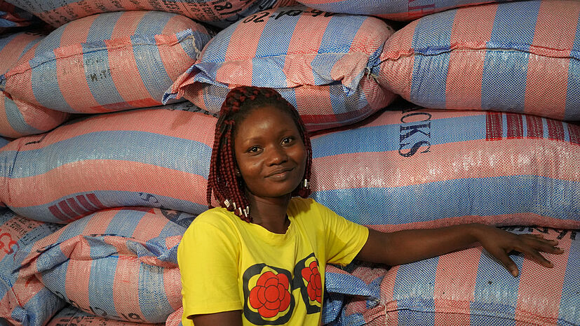 Angèle Wini Gnimle steht vor den exportfertigen Kakao-Säcke, die verschifft werden und schließlich in der GEPA-Bio-Schokolade landen. | Foto: GEPA – The Fair Trade Company / A. Welsing