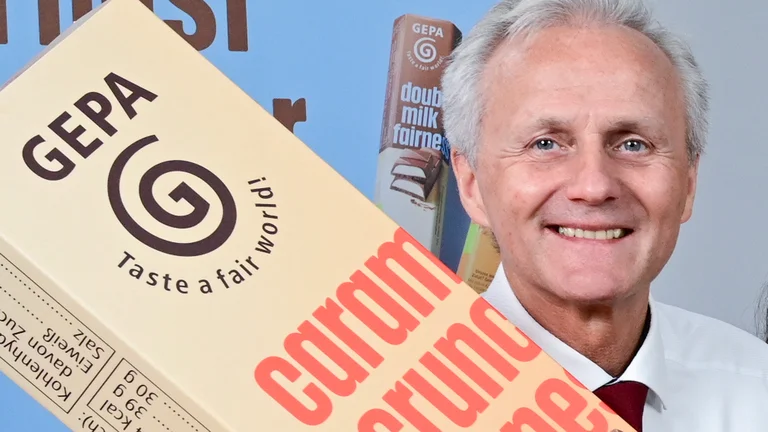 Matthias Kroth hält einen Riesenschokoriegel aus Pappe in der Hand.