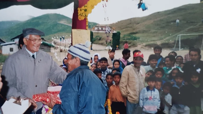 Brij Mohan klopt einem Teearbeiter auf die Schulter und überreicht Präsente.