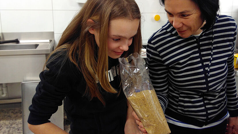 Wie riecht der GEPA-Vollrohrzucker Mascobado? Die 13-jährige Carla überzeugt sich beim Back-Workshop selbst. Hier mit Emmanuelle (rechts).