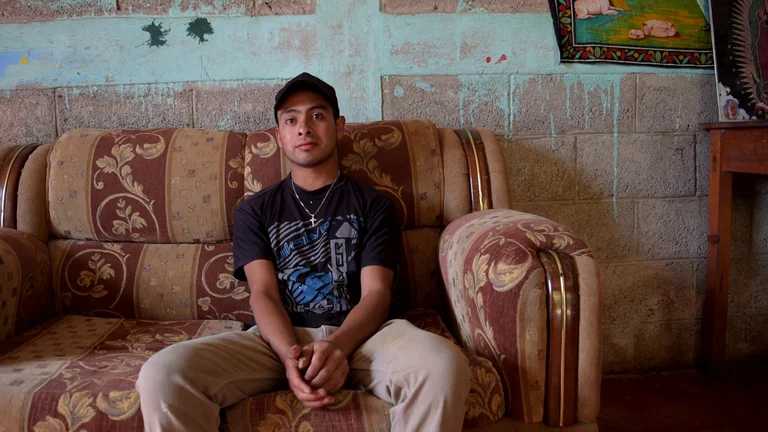 Junger Mann sitzt auf einem Sofa