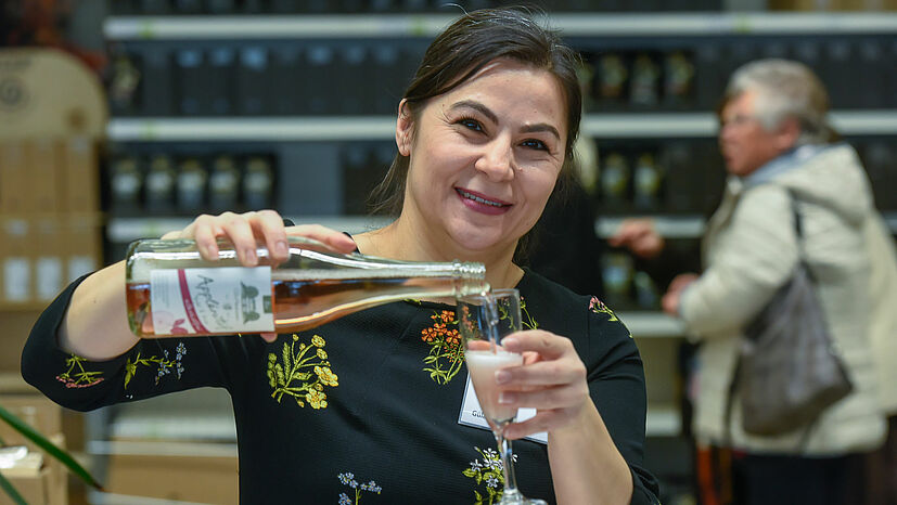 Gülay Can, Teamleiterin Kundenservice Weltläden und Gruppen, begrüßt die Ehrenamtlichen mit einem Glas Sekt.