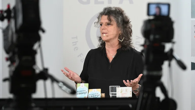 Andrea Fütterer mit Ansteckmikro, im Vordergrund die Kameras des Live-Stream-Aufbaus.