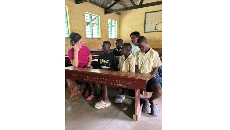 F&uuml;nf Sch&uuml;ler sitzen in B&auml;nken, neben den drei in der vorderen Reihe sitzt Franziska Bringe zugewandt und h&ouml;rt zu.
