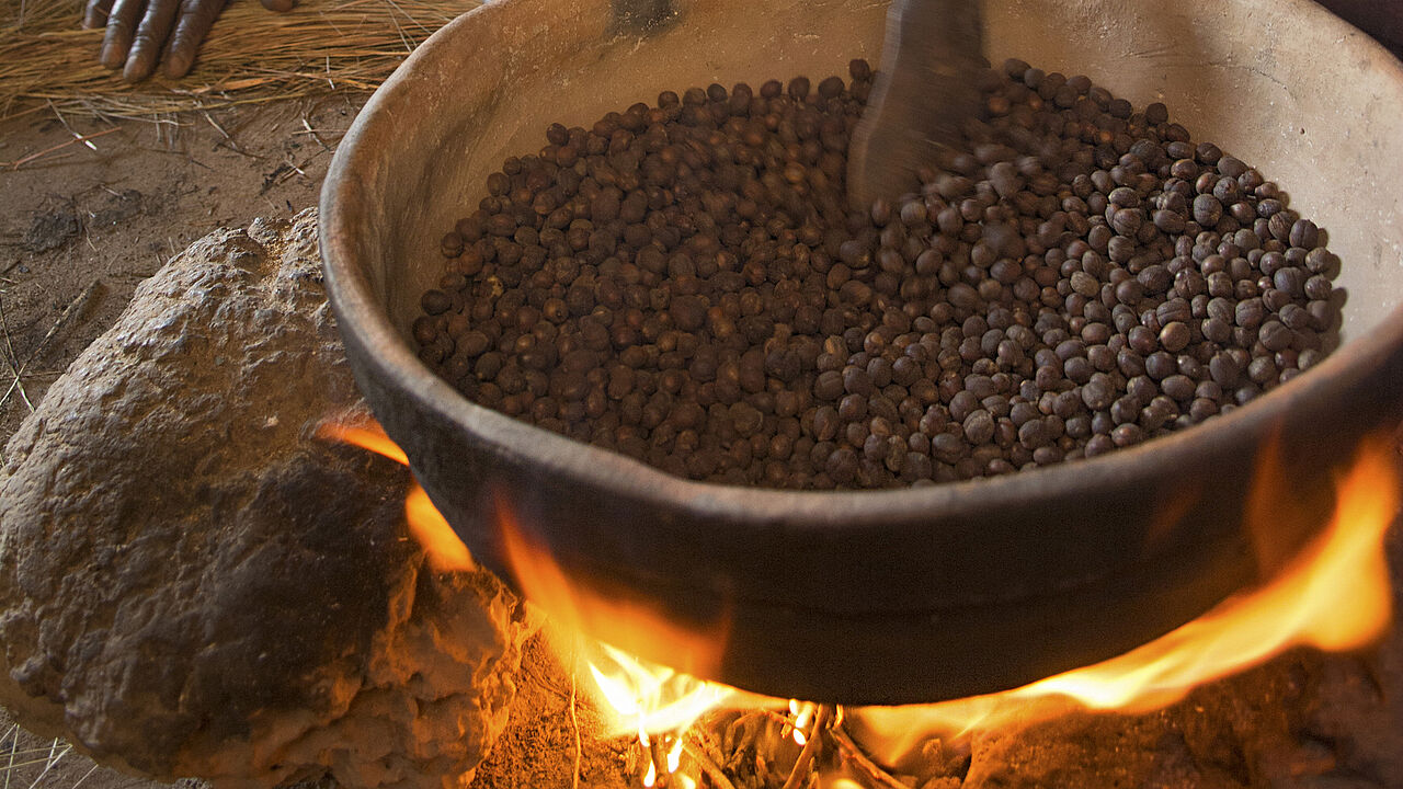 Marita Kigata röstet die Kaffeebohnen von Hand über dem offenen Feuer.