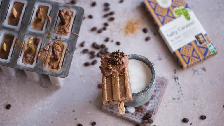 Selbstgemachtes Kaffee-Eis am Stiel, daneben eine Tafel Schokolade