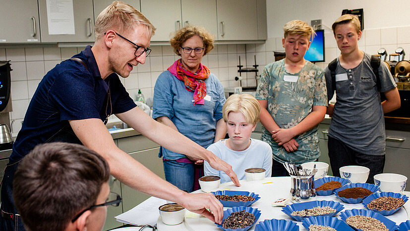 Frisch gerösteter Kaffeeduft zeigte den Jugendlichen den Weg zu unserem GEPA-Kaffeelabor: Hier erwartete sie GEPA-Sortimentsmanager Kaffee, Tobias Mehrländer (links) mit einer kleinen Aufgabe: „Welcher der Kaffees passt am besten zu welcher Schokolade?"