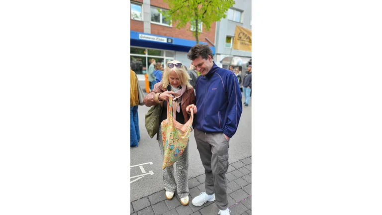Barbara Schimmelpfennig und Lutz van der Horst schauen lachen in eine bunte Tasche.