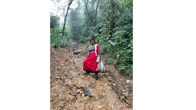 Catarina Velasco Toma, in langem Rock und bepackt mit Ausr&uuml;stung steht am Steilhang.