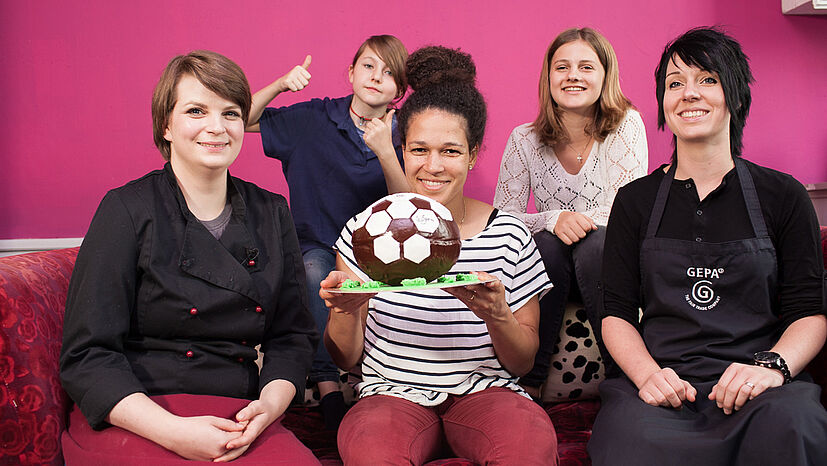 Das Backteam mit der fertigen Torte - v.l.: Konditormeisterin und Inhaberin von "la petite confiserie" Julia Bottler, Mia Piechaczek von der Gesamtschule Barmen, GEPA-Botschafterin und "Fußballerin des Jahres 2015" Celia Šašic, Anuschka Alfes vom Gymnasium Bayreuther Straße und Schokoladenexpertin Jennifer Schutz von der GEPA-Sortimentsabteilung.